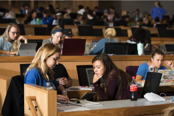 Students working together at a table in a lecture hall