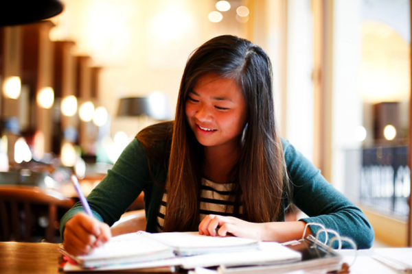 Young woman taking notes in a binder