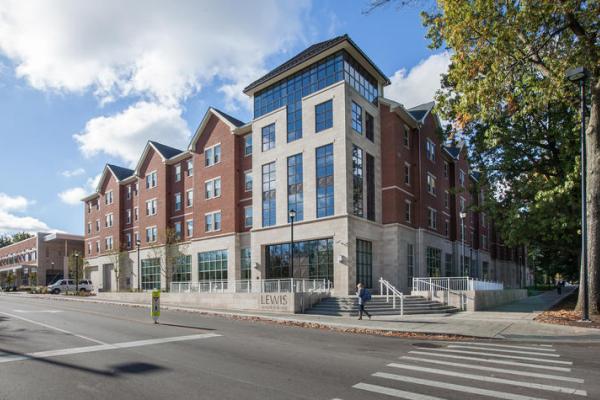 exterior shot of lewis honors college building with a blue sky and white clouds, a green tree to the side