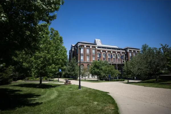 a multistory brick building on a college campus with paths and trees