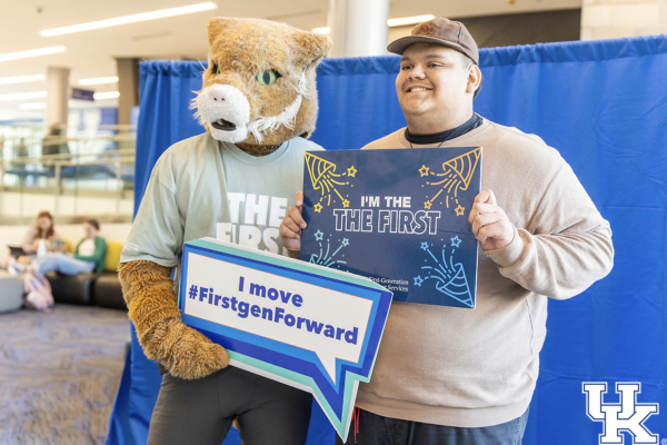 bowman the wildcat with a student holding first-gen student enthusiasm signs