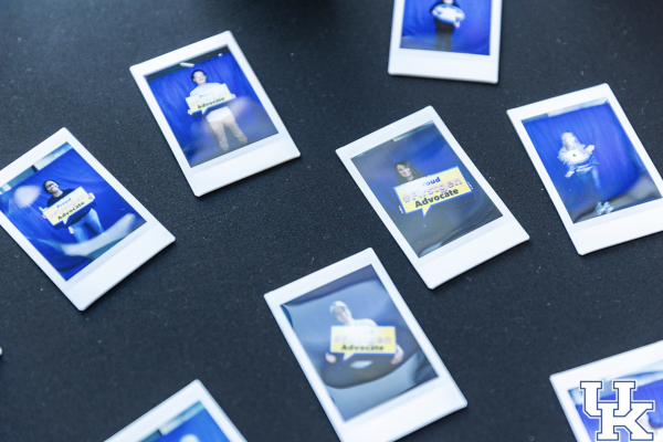polaroids of students holding first gen signs sit on a tabletop