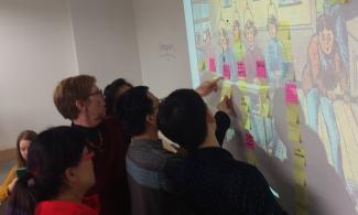 group of faculty putting sticky notes on a projected image on a wall