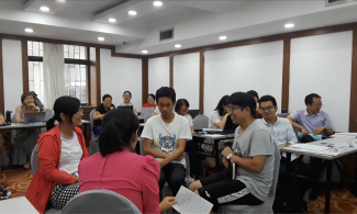 four faculty from qingdao university acting out a class scenario while their colleagues observe