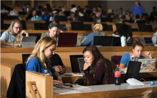 Students working together at a table in a lecture hall