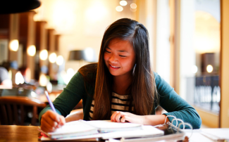Young woman taking notes in a binder