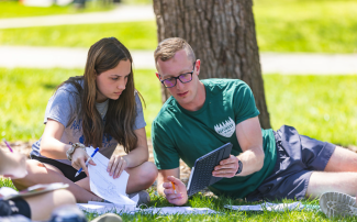 Two students looking at the student on the right's tablet together