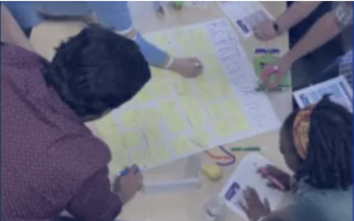 Workshop participants actively working on a project around a table.